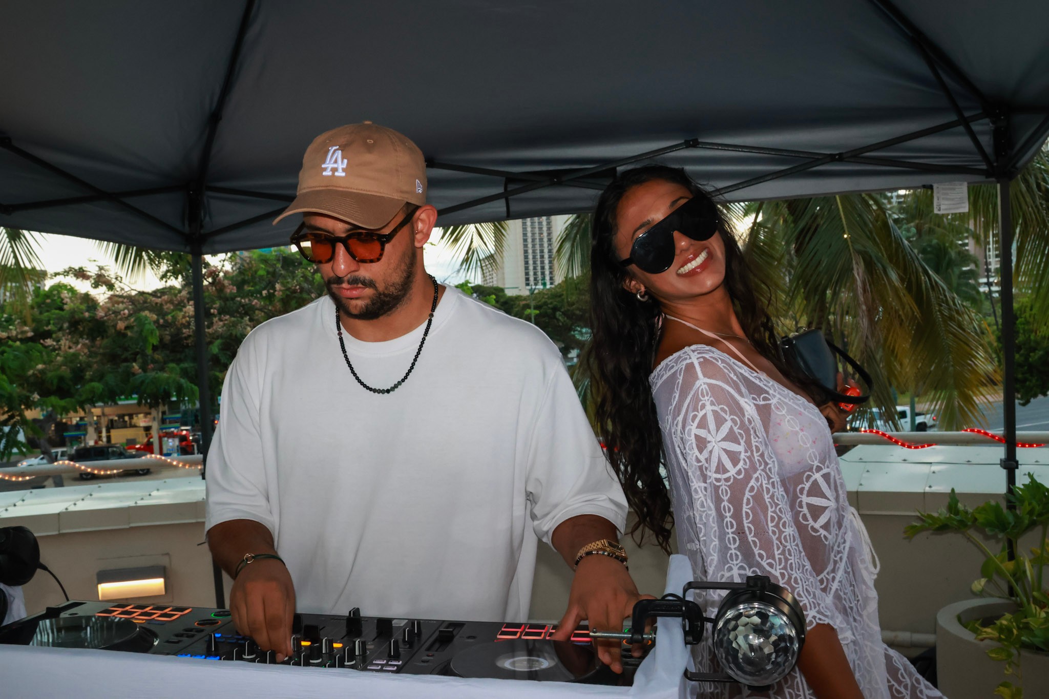 DJ under tent, palm trees